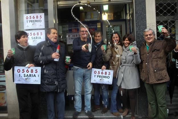 Dueños y trabajadores de la administración de Lotería de la avenida Lehendakari Aguirre, en Bilbao, celebran haber vendido el Gordo. :: efe
