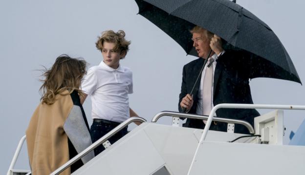 Trump se tapa y su mujer e hijo se mojan. A la derecha, Stormy Daniels. :: AFP