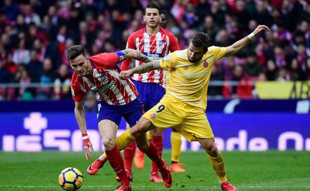 Saúl intenta retener el balón ante Portu.