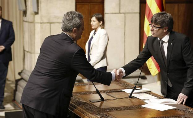 Forn (i) da la mano a Carles Puigdemont (d) durante el acto de toma de posesión de los nuevos consejeros catalanes en 2017. 