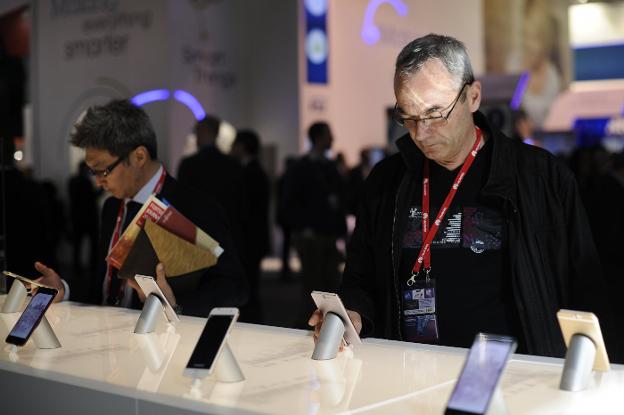Dos personas prueban varios móviles en la última edición del Mobile World Congress en Barcelona. :: inés baucells