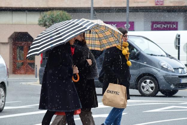 Mujeres protegiéndose con paraguas en Logroño