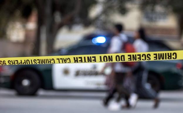 Un grupo de personas camina frente a la zona acordonada tras el tiroteo registrado en Parkland. 