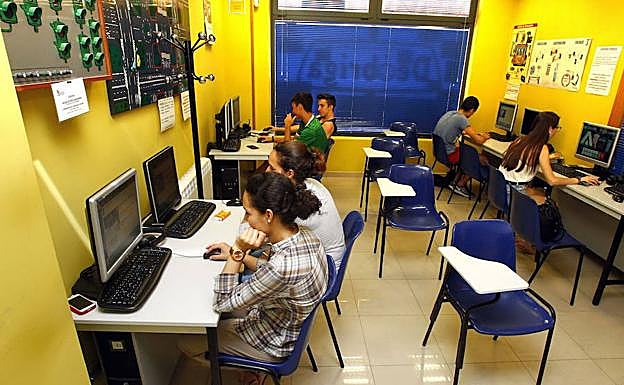Varios aspirantes a conductores preparan el examen teórico en el ordenador. 
