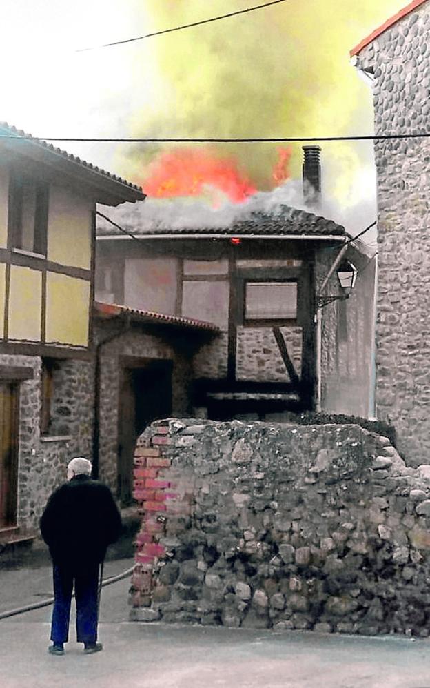 Un anciano observa el incendio en la casa. :: bomberos forestales