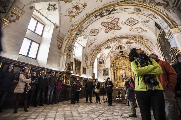 La guía describe ante los visitantes los frescos de la sacristía y su peculiar suelo de alabastro