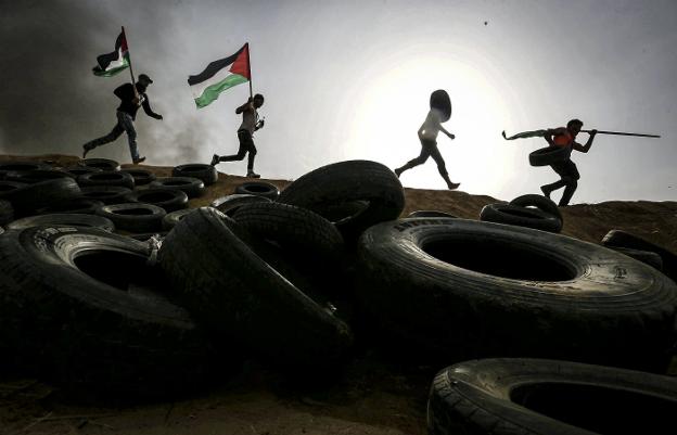 Palestinos colocan neumáticos en la frontera con Israel, a los que prenderán fuego para afectar el trabajo de los francotiradores. :: reuters