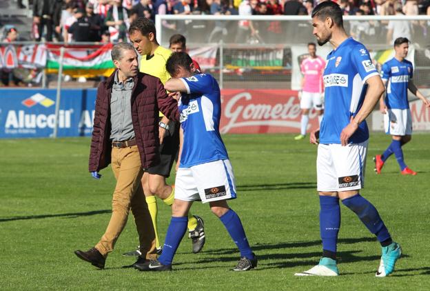 Antxon Muneta se retira del campo acompañado por el doctor Vicente Elías. :: fernando díaz