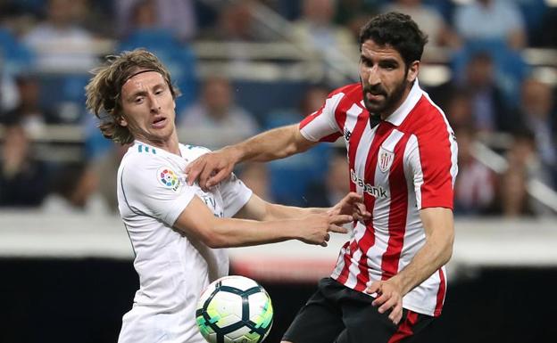 Modric disputa un balón con Raúl García. 