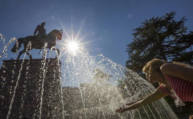 Una turista se refresca en la estatua del Espartero