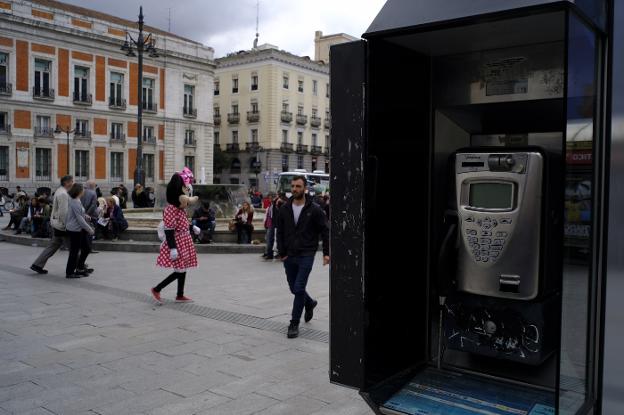 En la Puerta del Sol, una de las 18.161 cabinas de teléfono que todavía quedan en España. :: josé ramón ladra