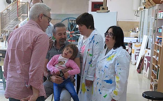 José María Cano, exmiembro del grupo musical Mecano, nuevo padrino de la campaña 'Soy Cómplice', sostiene a una niña. 