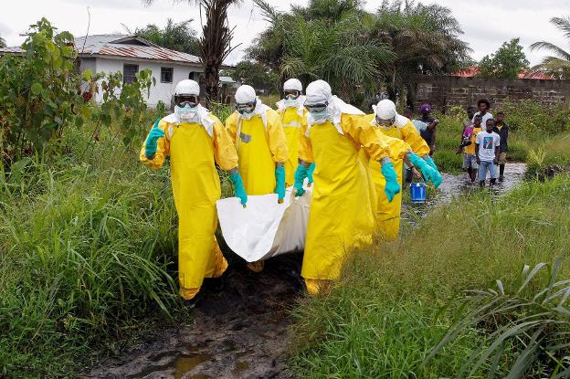 Los sanitarios trasladan el cadáver de una victima del ébola en noviembre de 2014. :: efe
