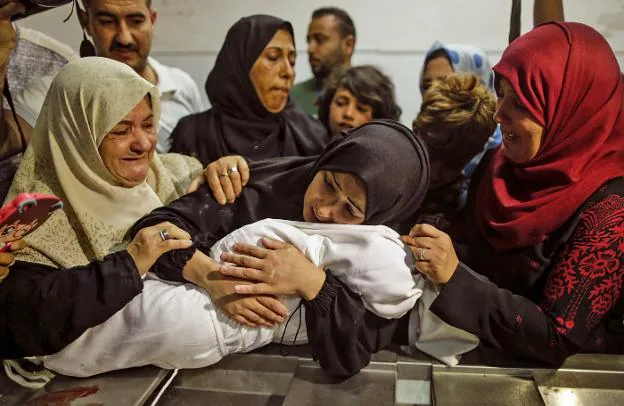 La madre de Laila al Gandor, una bebé fallecida por inhalar gases lacrimógenos, se aferra a su hija. :: afp