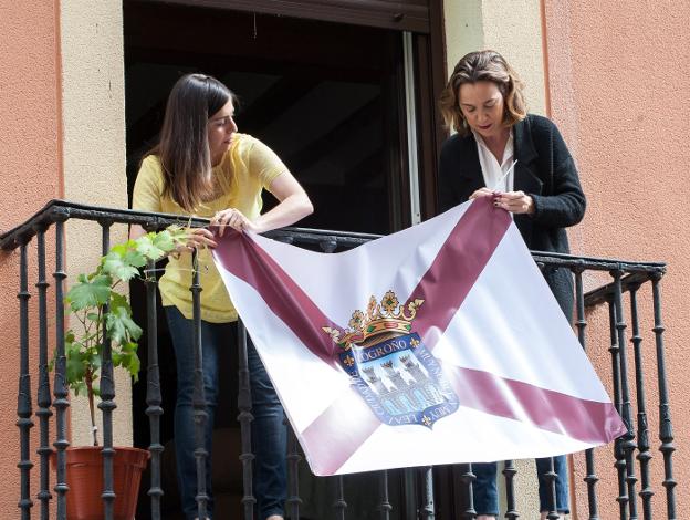 La alcaldesa coloca junto a una vecina del 28 de Portales la primera bandera de este año. :: díaz uriel