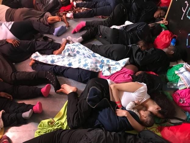 Varios refugiados, entre ellos varios niños, duermen en el 'Aquarius' durante su traslado a Valencia. :: lauren king / afp