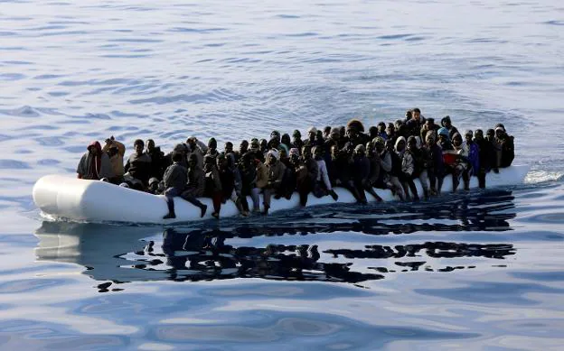 Decenas de inmigrantes, instantes antes de ser rescatados por guardias costeros libios en el Mediterráneo. :: Hani Amara / reuters
