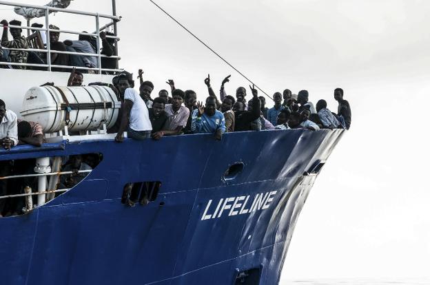 Un grupo de inmigrantes saluda desde la proa del 'Lifeline'. :: afp