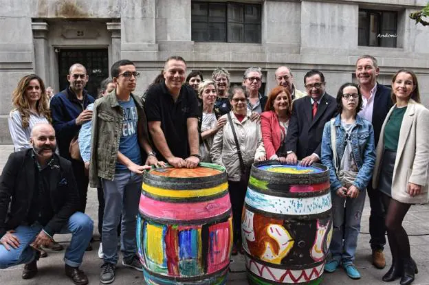 Iñaki Murillo, de pie y de negro,  posa en Bilbao con alguna de las barricas cedidas con responsables y artistas de FormArte. :: Andoni Rentería