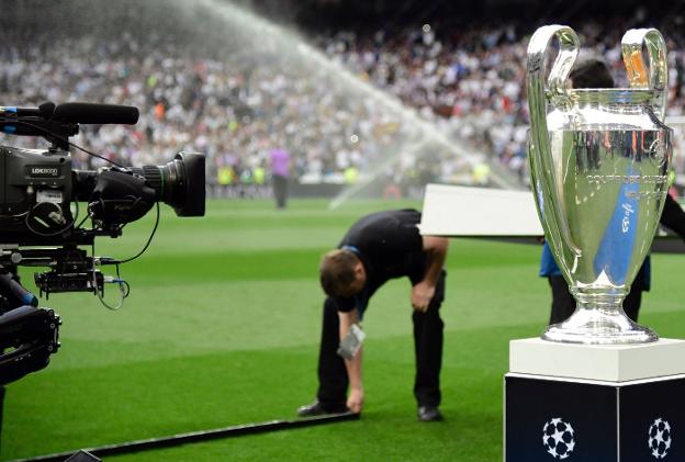 Un cámara de televisión filma la copa de la Champions antes de arrancar la última final, que conquistó el Real Madrid. :: afp