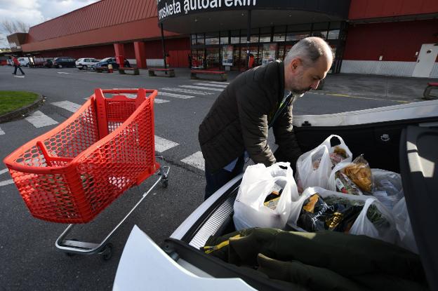 Un hombre carga en el coche las bolsas de la compra. :: Luis Ángel Gámez