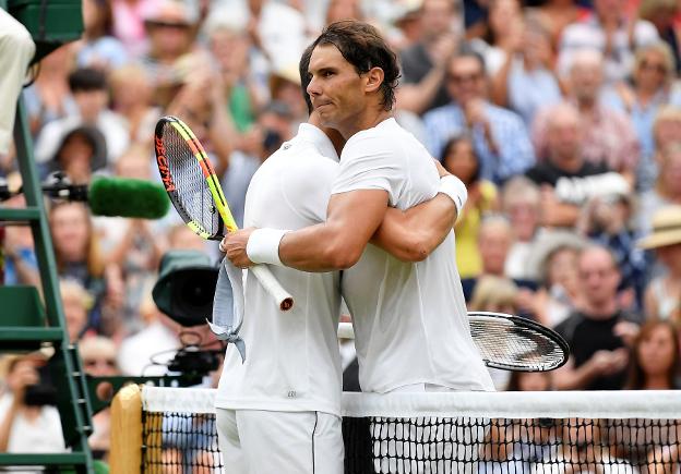 Novak Djokovic y Rafael Nadal se abrazan en la red tras el punto definitivo. :: Reuters