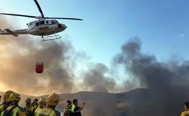 Un helicòptero se dispone a soltar agua sobre un incendio que tuvo lugar el año pasado en el vertedero de Logroño. 