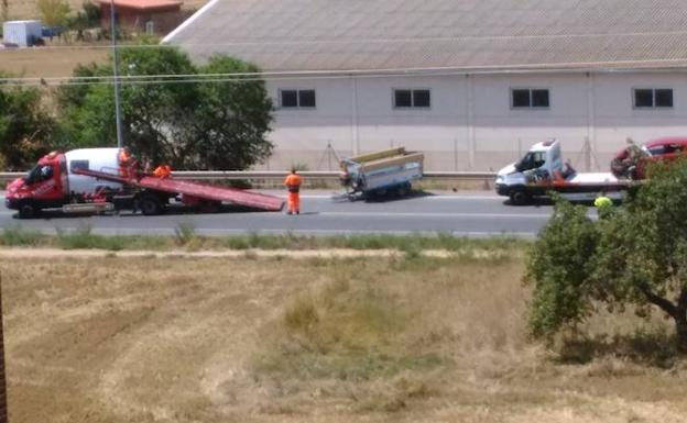 Una grúa recoge un remolque implicado en el accidente. 
