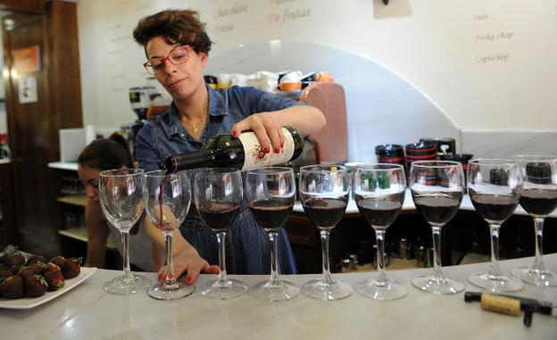 Una camarera sirve copas de vino en un bar de la capital riojana. :: M. HERREROS