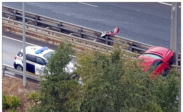 El vehículo accidentado y una patrulla de la Policía Local de Logroño. 