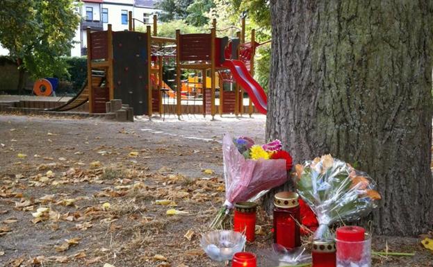 Flores y velas en el lugar del crimen.