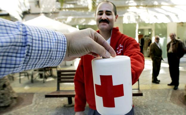 Un voluntario de Cruz Roja pide la colaboración ciudadana. 