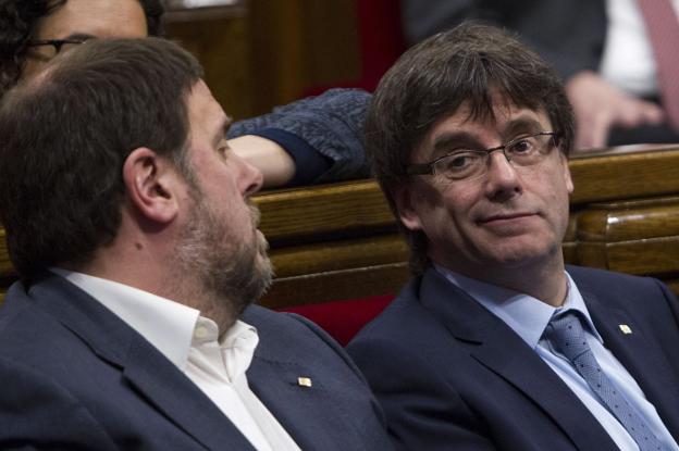 Junqueras y Puigdemont charlan en un pleno del Parlamento de Cataluña. :: Quique García / efe