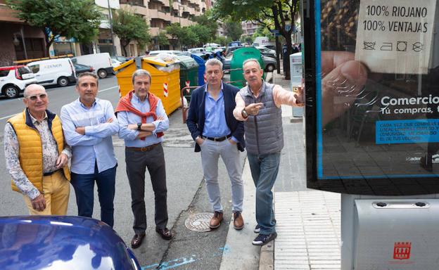 Madorrán, Ulibarrena, Aguado, Osaba y Martínez Bergés posan junto a un 'mupi' comercial con contenedores de fondo. :: 