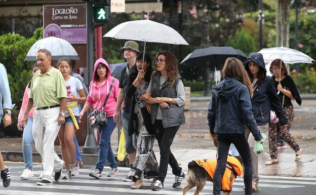 Paseantes con paraguas por Logroño. 