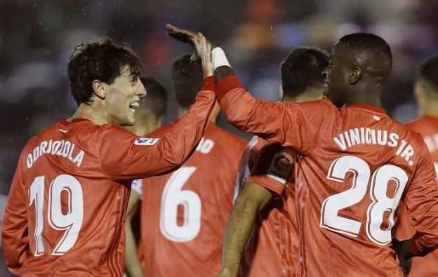 Odriozola y Vinícius se felicitan después del gol del donostiarra, terc ero del Real Madrid. :: efe