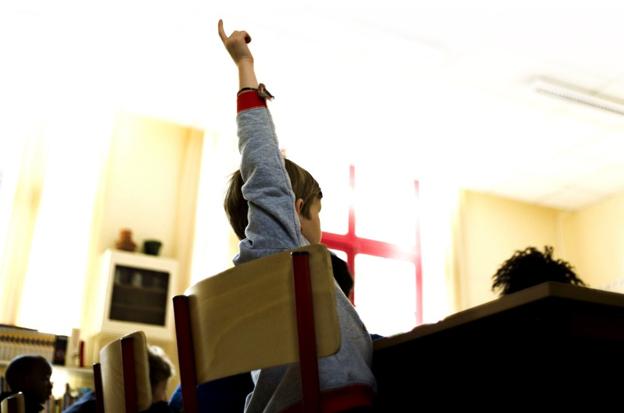 Un alumno levanta la mano en clase. :: l.r.