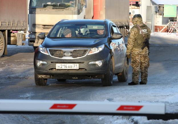 Un guardia de fronteras ucraniano para un coche ruso. :: reuters