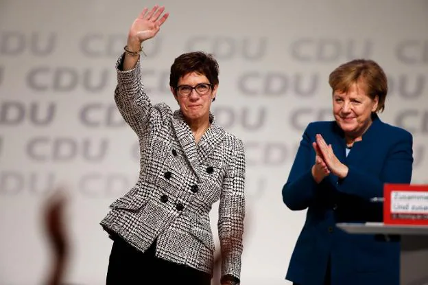 Kramp-Karrenbauer saluda al millar de delegados reunidos en Hamburgo mientras es aplaudida por Merkel. :: Odd ANDERSEN / AFP
