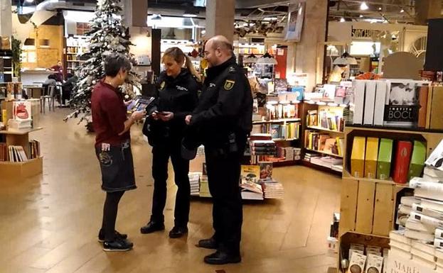 Dos policías aconsejan al personal de un comercio logroñés.