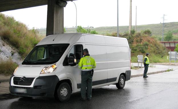 Una pareja de agentes supervisa una furgoneta.