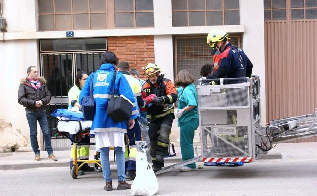 Bomberos y profesionales médicos rescatan y tratan al niño. 