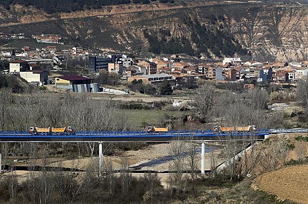 Camiones en la prueba de carga realizada en el nuevo puente sobre el Leza. Al fondo, la localidad de Murillo de Río Leza. :: 
