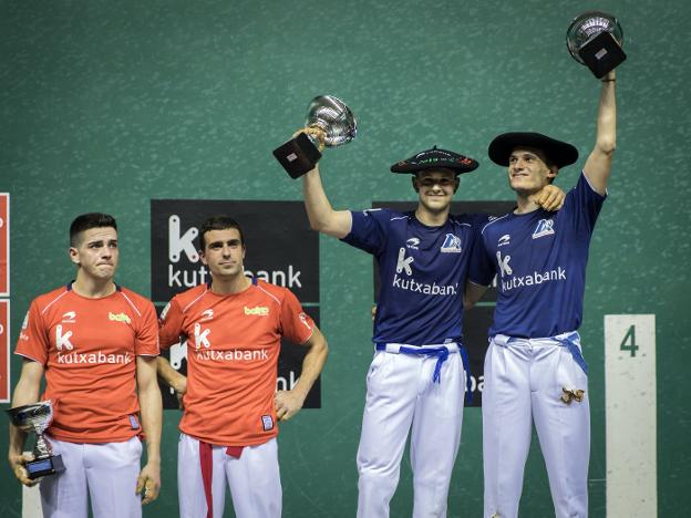 Caras de decepción de Rubén Salaverri y Asier Agirre mientras Elordi y Oier Etxebarria levantan sus trofeos. :: 
