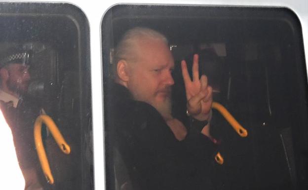 Julian Assange, fundador de Wikileaks, hace la 'V' de victoria tras ser detenido. 