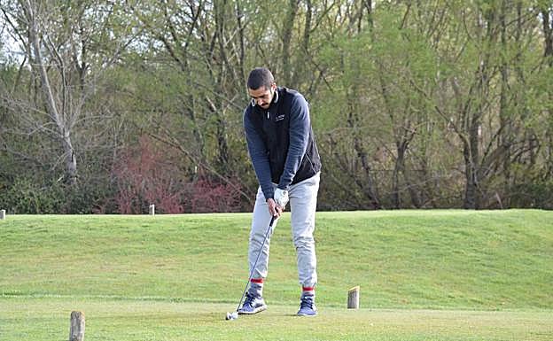Un aficionado jugando a golf.