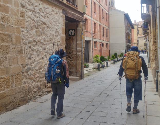 Dos peregrinos, junto a la oficina de turismo, que abre hoy. 