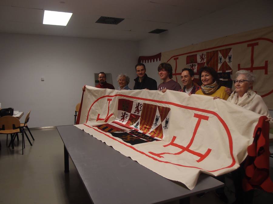 Miguel Sáinz, Alfredo Iturriaga y Elvira Mendoza, enseñan el nuevos estandarte junto a otros voluntarios.