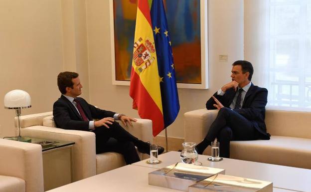 Pablo Casado y Pedro Sánchez se dialogan en un salón de la Moncloa.