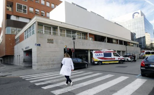 Una sanitaria cruza un paso de peatones junto al Hospital Clínico.